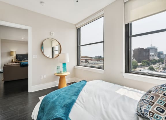 a bedroom with a bed and three windows