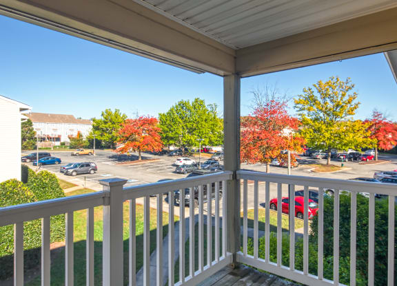 the view from the balcony of a building with cars in a parking lot