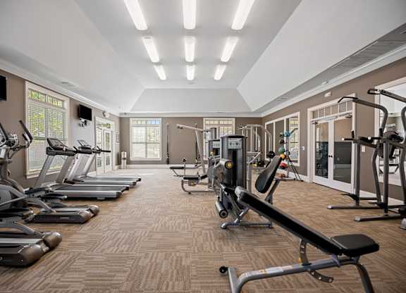 A gym with treadmills, elliptical machines, and weight machines.