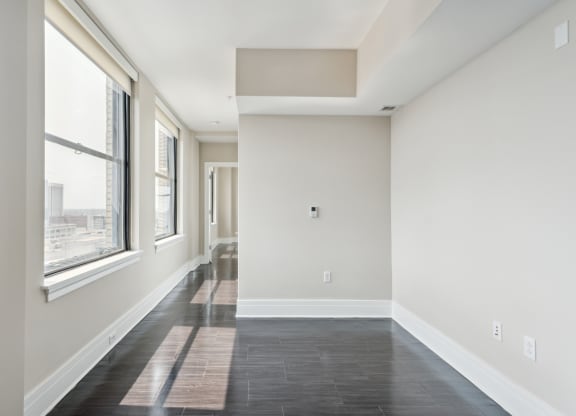 an empty room with large windows and a black tile floor