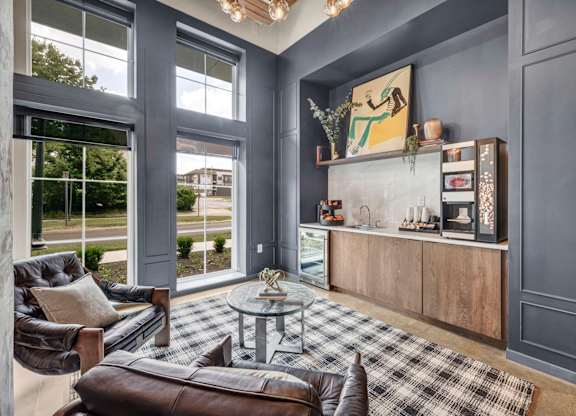 A grey living room with a black and white checkered rug.