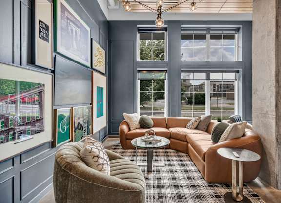 A living room with a brown couch, a grey armchair, and a coffee table.