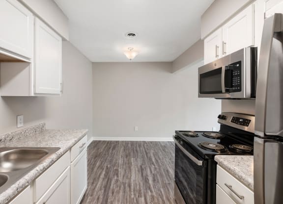 a kitchen with white cabinets and a black stove top oven