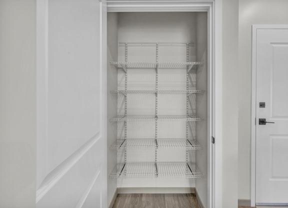 Empty white shelves in a white pantry.