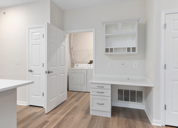 a kitchen with white cabinets and white appliances and a white desk at The Charleston, Columbus, 43221