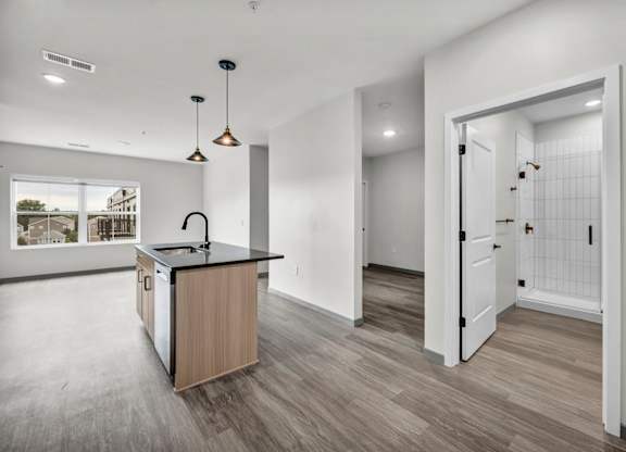A kitchen with a black counter top and a wooden island.