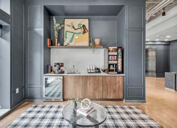 A modern kitchen with a large island and a glass table in the center.
