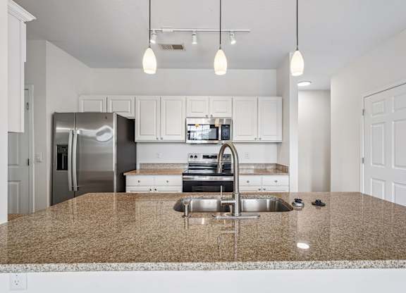 A kitchen with granite countertops and stainless steel appliances.