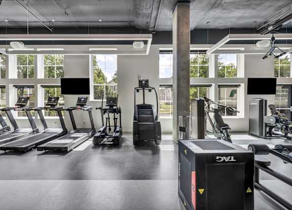 A gym with treadmills, elliptical machines, and other exercise equipment.