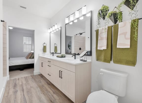 a bathroom with white walls and wood flooring
