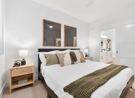a bedroom with a bed and two mirrors on the wall