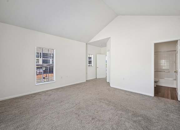 A white room with a carpeted floor and a picture on the wall.