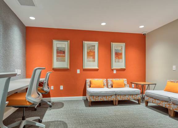 A room with orange walls and a grey carpet.
