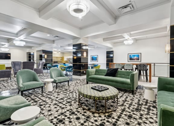 a lobby with green couches and chairs and a black and white checkered floor