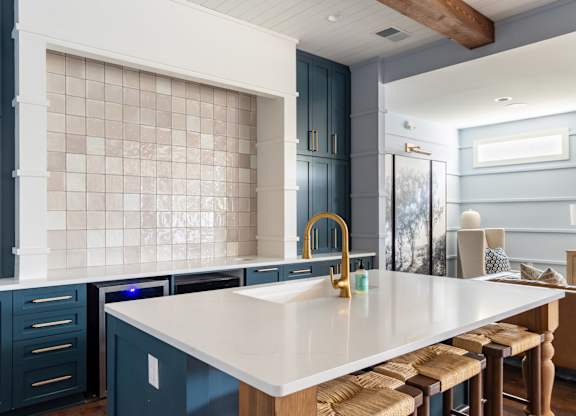 A kitchen with a white countertop and blue cabinets.