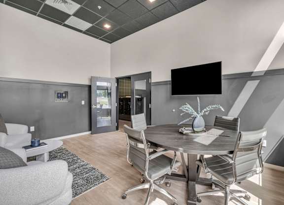 A modern dining room with a grey table and chairs.