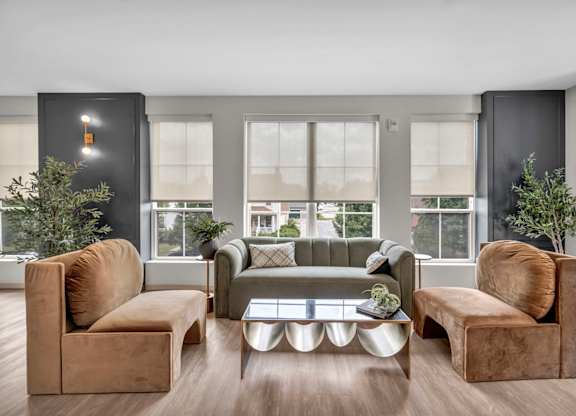 A living room with brown and grey furniture and a large window.