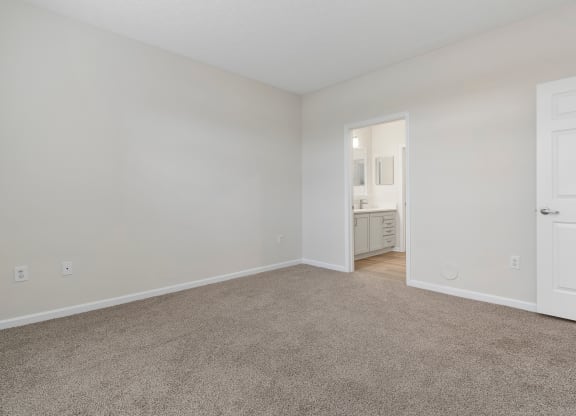 a bedroom with carpet and a door to a bathroom at The Charleston, Ohio