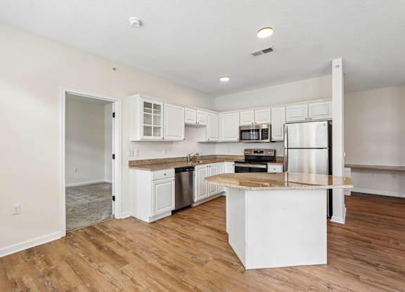 A kitchen with white cabinets and a wooden island.