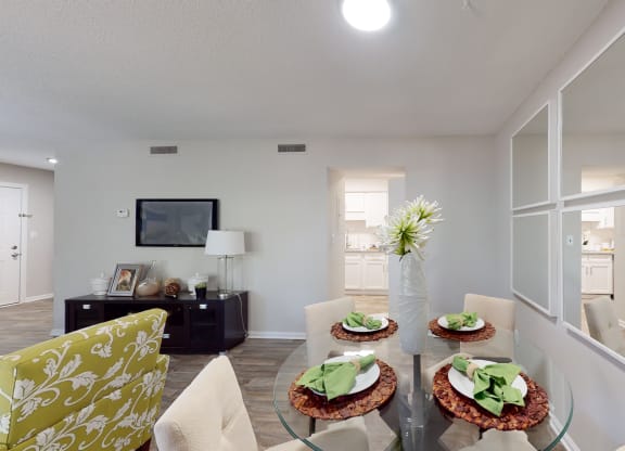 a living room with white walls and a glass table with three plates of food on it