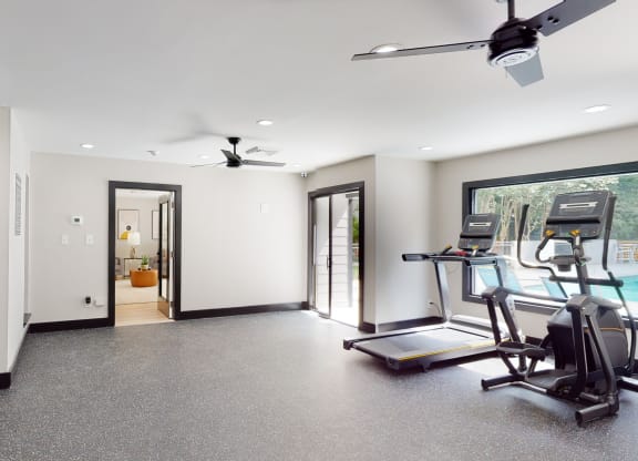 a workout room with treadmills and a treadmill