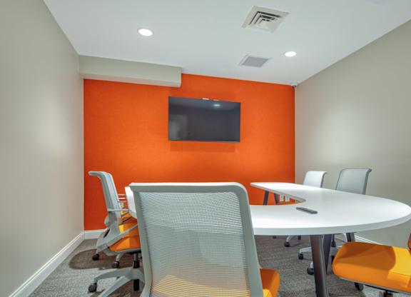 A conference room with a white table and chairs.