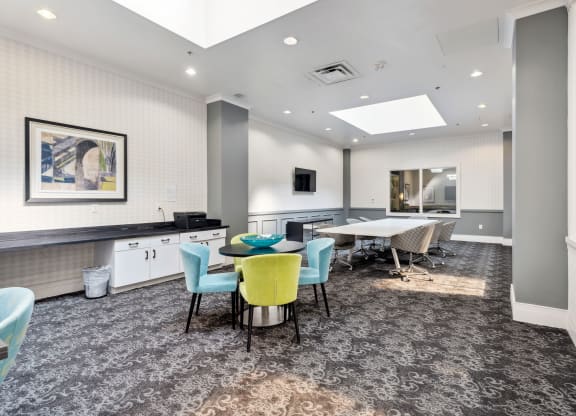 a common area with a table and chairs and a kitchenette