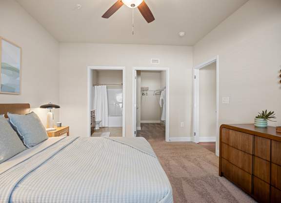 A bedroom with a large bed and a ceiling fan.