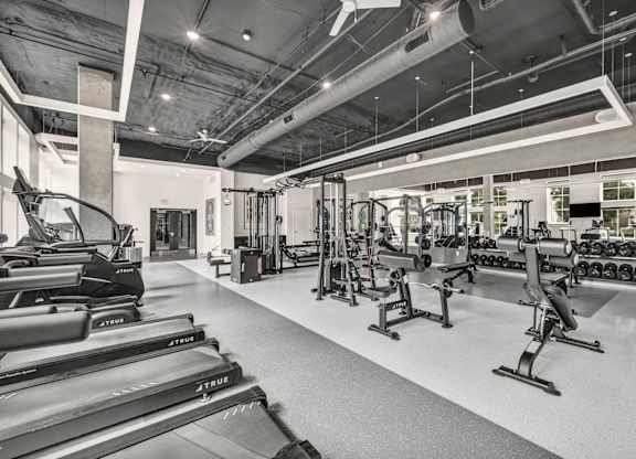 A gym with treadmills, weights, and other exercise equipment.