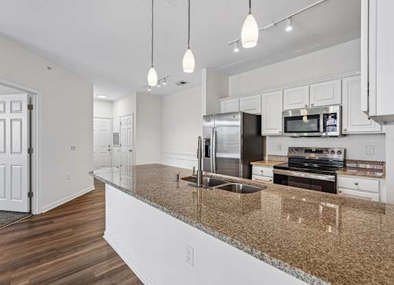 A kitchen with granite countertops and stainless steel appliances.