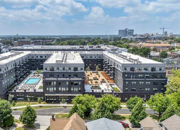 A large, modern building complex with a pool in the center.