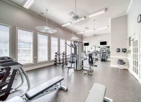 A spacious gym with a variety of equipment including treadmills, weights, and exercise machines.