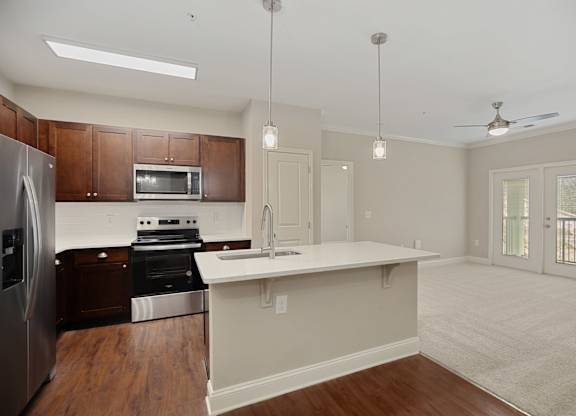 A kitchen with a refrigerator, oven, and microwave.