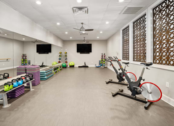 a gym with exercise equipment and a tv on the wall