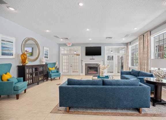 a living room with blue couches and chairs and a fireplace