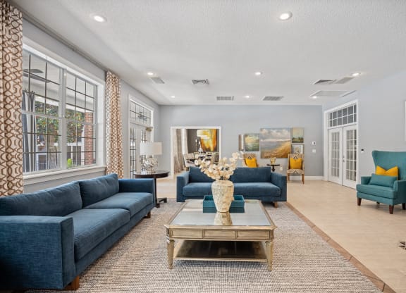 a living room with blue couches and chairs and a table