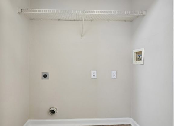 A white bathroom with a white tub and a white towel rack.