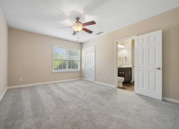 A room with a ceiling fan and carpeted floor.
