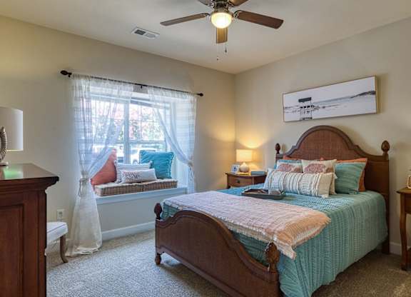 A bedroom with a bed, nightstand, and window.