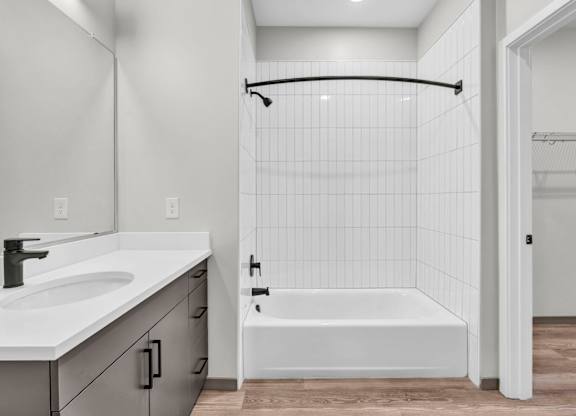 A white bathroom with a white tub and a white sink.