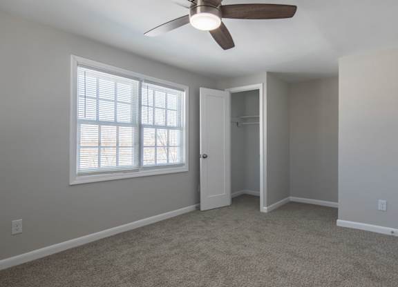 A room with a ceiling fan and a window.