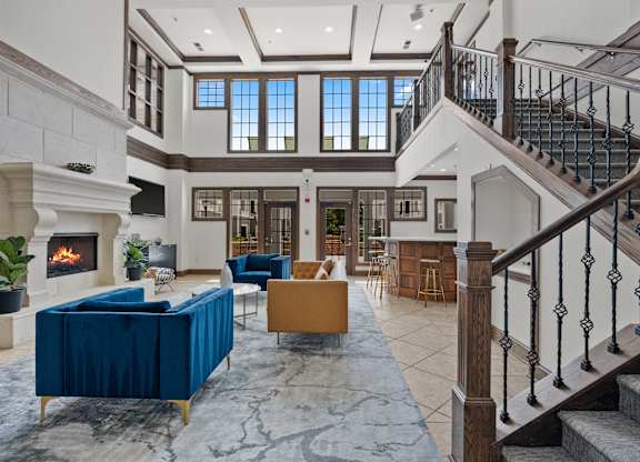 A large, open living room with a staircase and a fireplace.