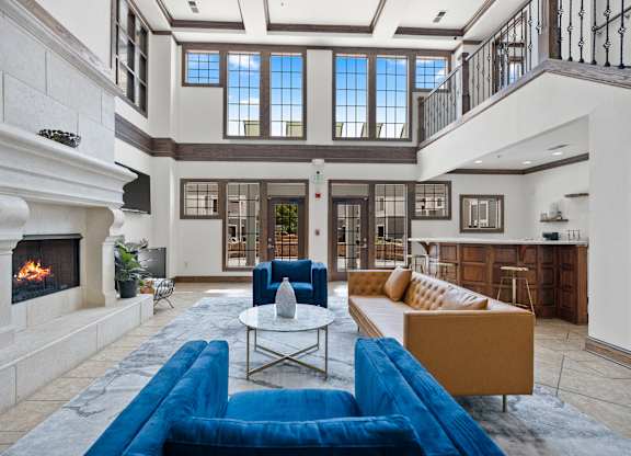 A large, well-lit living room with a fireplace and a blue sofa.