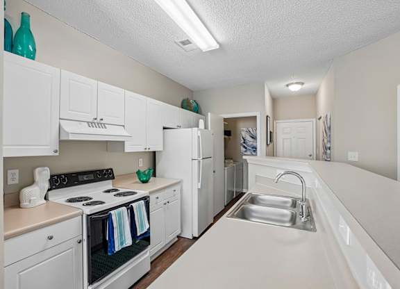 A kitchen with white cabinets and a black oven.