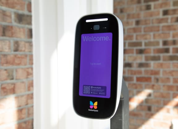 a iphone sitting on a pole in front of a brick wall