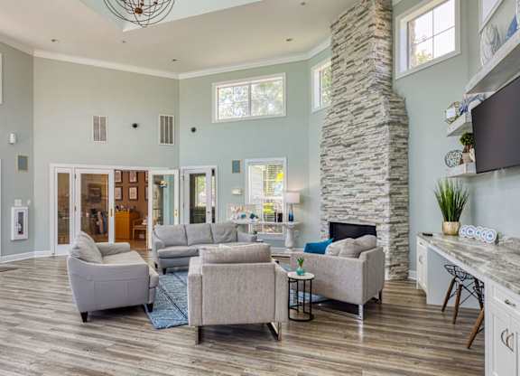 A spacious living room with a stone pillar and a kitchen area in the background.