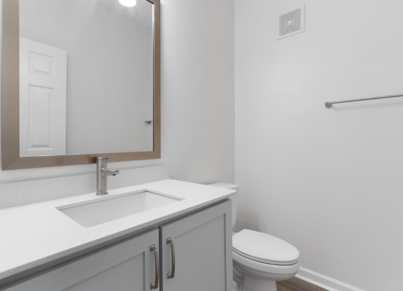 a bathroom with a sink and a toilet and a mirror at The Charleston, Columbus