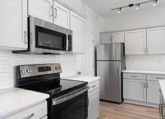 a kitchen with white cabinets and stainless steel appliances at The Charleston, Columbus, OH