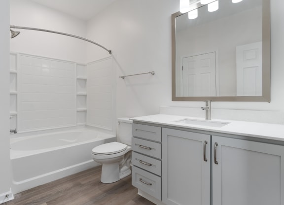 a white bathroom with a tub and a sink and a toilet at The Charleston, Columbus, 43221