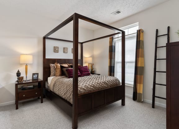 a bedroom with a four poster bed and a ladder at The Charleston, Columbus, OH, 43221